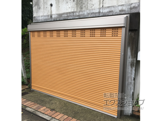 神奈川県横浜市のLIXIL リクシル（トステム）のガレージシャッター ガレージシャッタークワトロ 電動式 外部付タイプ 木目調（換気孔スラット付）※外部停電時開閉機構 施工例